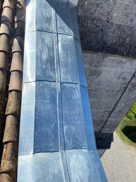 Équipe de couvreurs zingueurs expérimentés travaillant sur un toit en zinc à Sauve