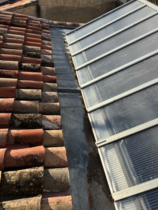 Couvreur en train de poser une verrière en zinc sur une toiture à Nîmes.