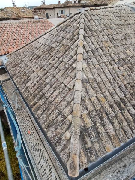 Vue rapprochée de tuiles canal anciennes en cours de pose par un artisan couvreur de Masclaux Toiture sur une toiture rénovée à Vic le Fesc dans le Gard.