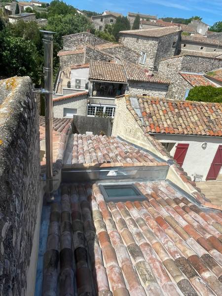 Pose d'une fenêtre de toit Velux moderne sur une couverture traditionnelle en rénovation par Masclaux toiture.