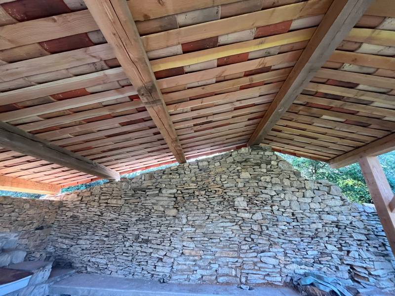 Vue d'ensemble d'une charpente sur mesure en bois brut fraîchement installée sur une maison neuve à Nîmes.