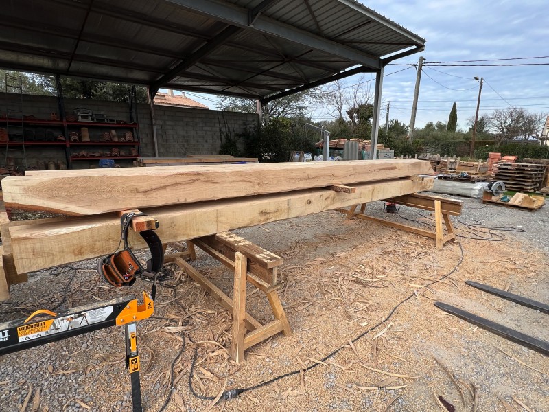 Charpentier à Uzès en train de travailler sur une charpente en chêne